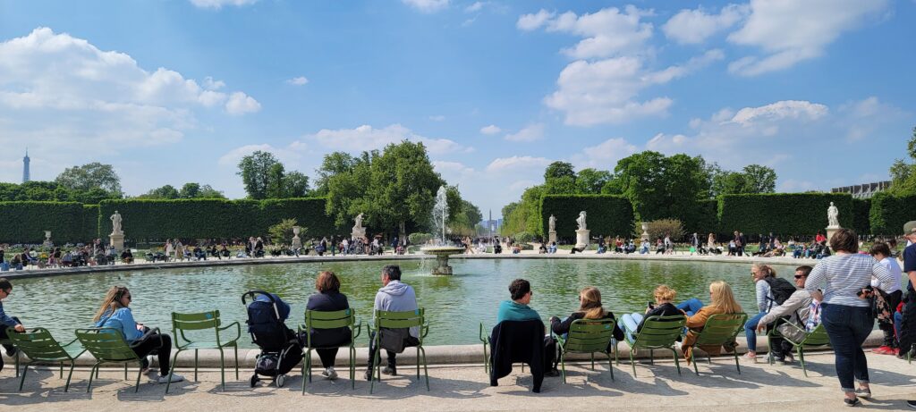 Fountain with people seated all around it at Jardin des Tuileries, Paris, France on a sunny day.