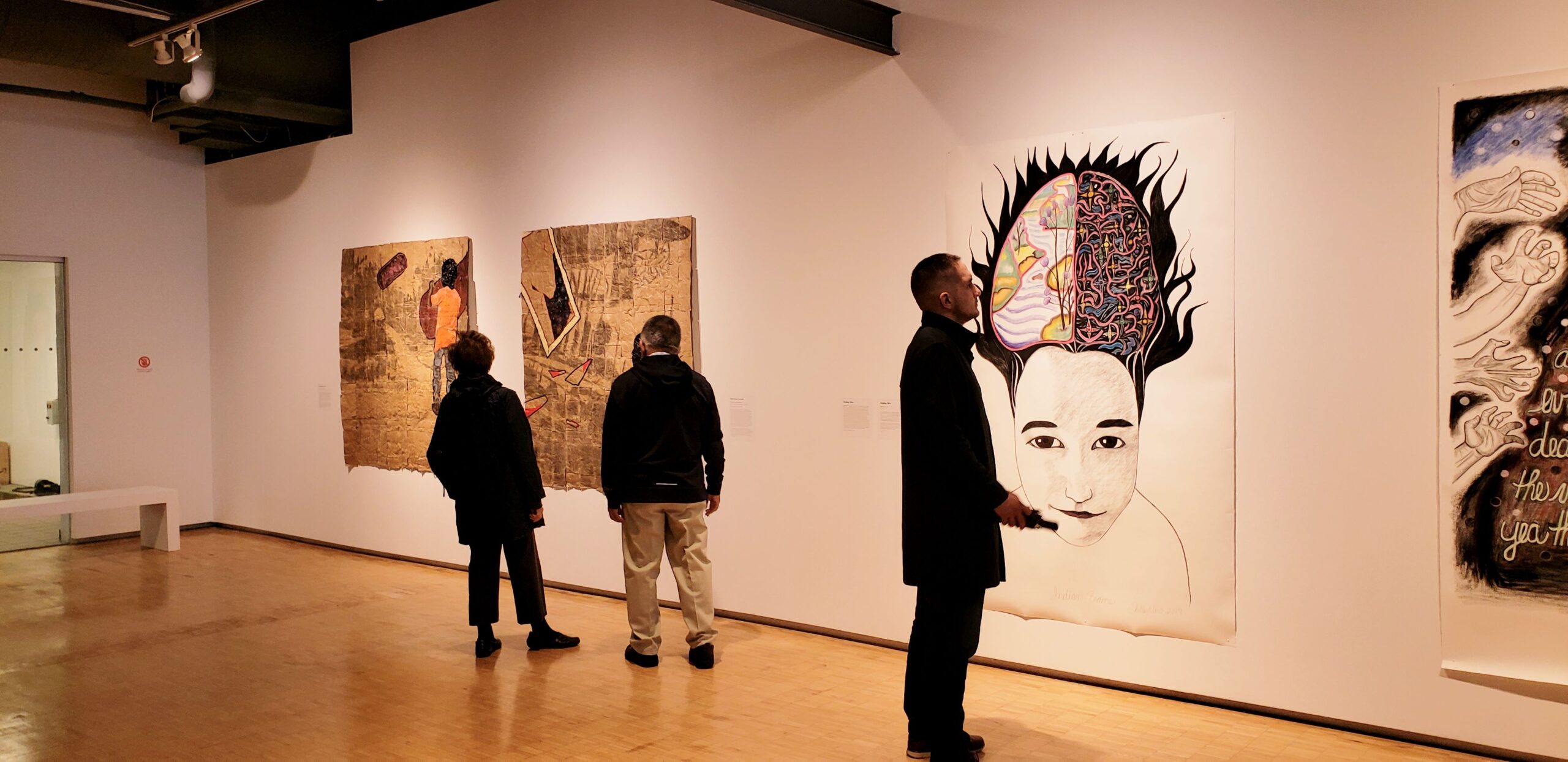 People looking at art hanging at a gallery at the Toronto Harbourfront.