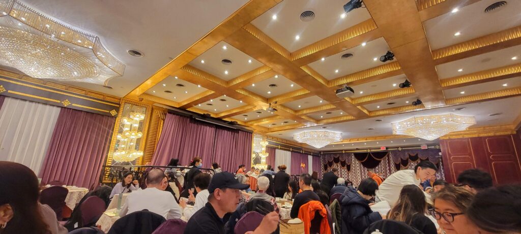 Full restaurant of diners and elegant interior of Casa Victoria with crystal chandeliers that serves dim sum.