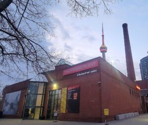 Exterior of The Power Plant at the Harbourfrount Centre, free to visit in Toronto, shown with the CN Tower in the background.