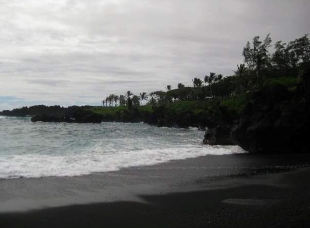 Black sand beach in Maui on a rainy day.