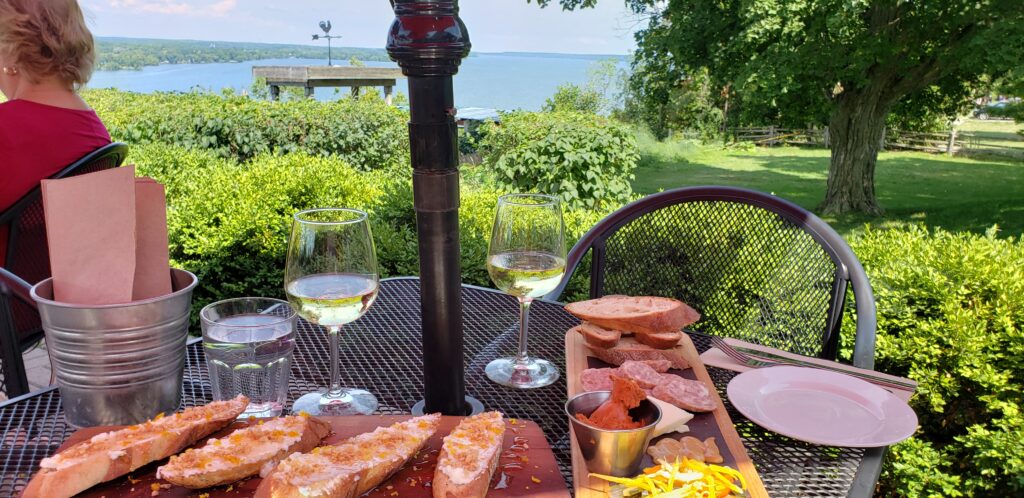 Wine and charcuterie board at a waterfront restaurant patio outside.