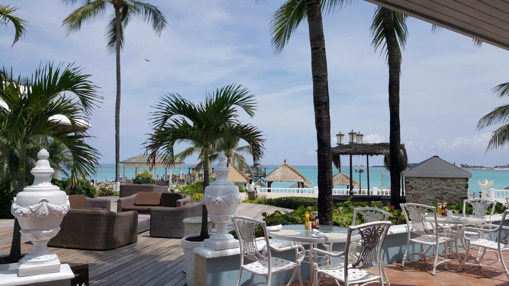 Some tables and seating for outdoor dining with ocean views at Sandals Royal Bahamian.