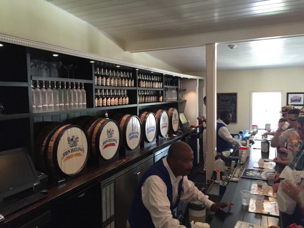 People tasting whiskey at the bar at the end of the John Watlings distillery tour.