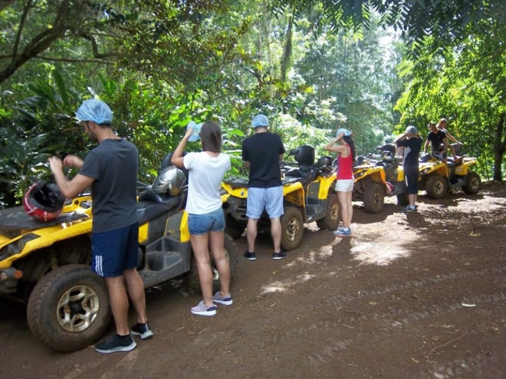 Putting on helmets in front of yellow ATVS for excursion in Moorea.