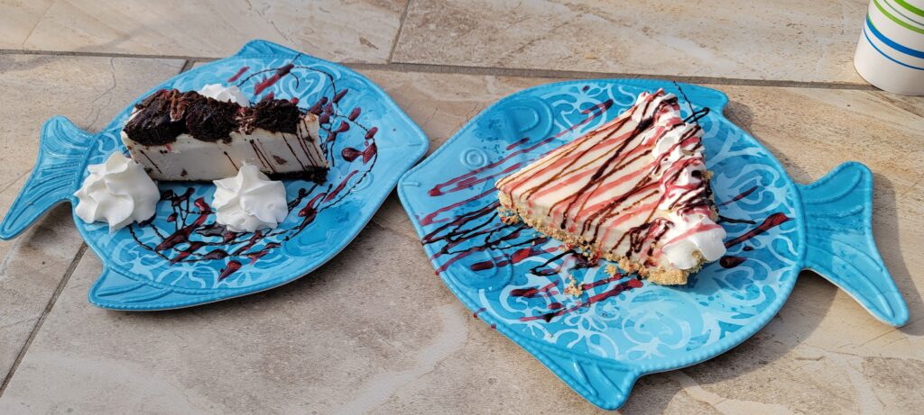 Two slices of pie served on decorative blue fish plates.