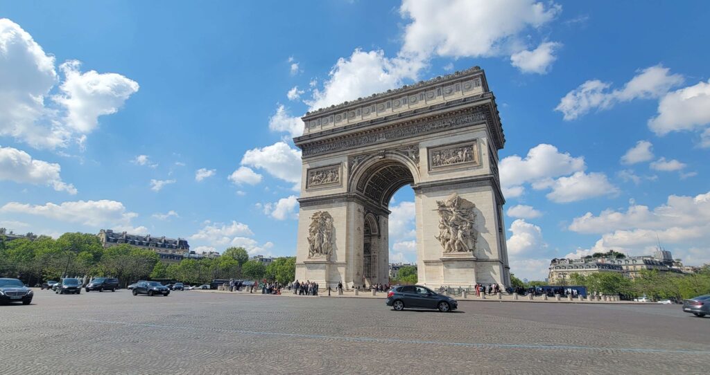 Arc de Triomphe from across the street with cars driving by.