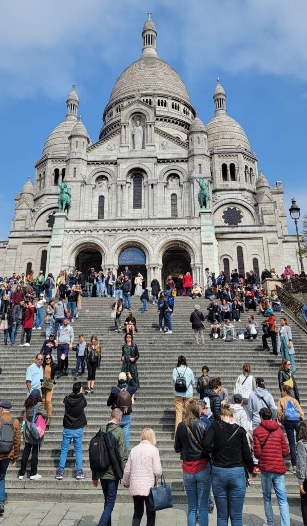 Staircase with many visitors and exterior of La Basilique du Sacré-Coeur de Montmartre, Paris, France