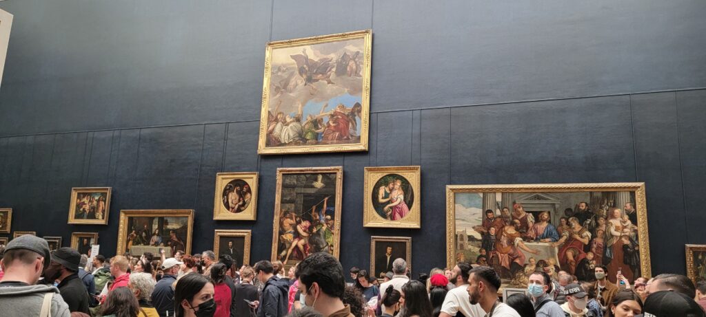 Framed religious paintings on a wall in the Louvre museum in Paris.