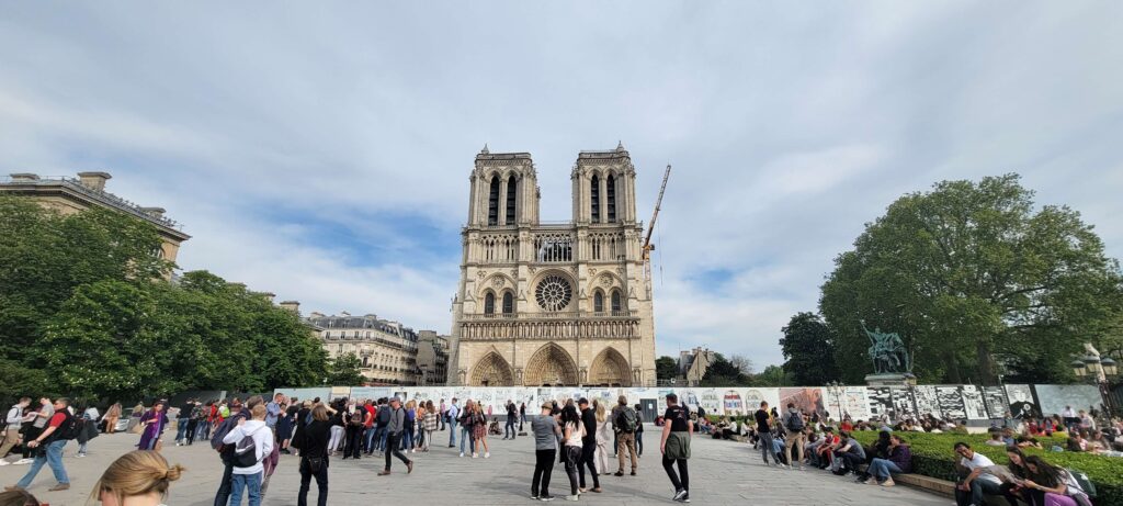 Notre Dame exterior with many visitors outside around the cathedral in Paris, France.