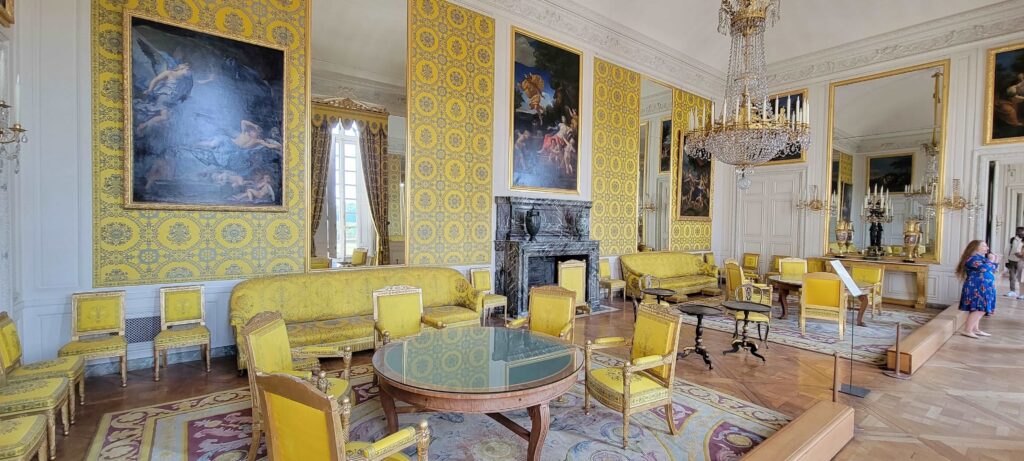 Large living room decorated mainly yellow with grand decor in The Grand Trianon.