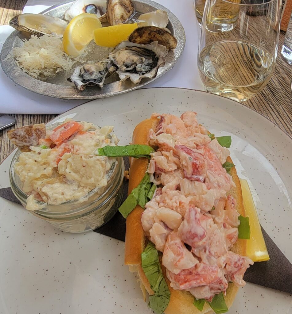 Lobster roll, potato salad, oysters and glass of white wine from Tide and Vine in Niagara.