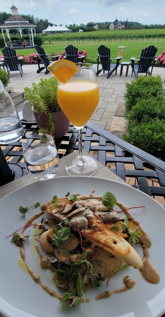 Mushrooms on Toast with a mimosa and beautiful view of vineyards in Niagara-on-the-Lake.