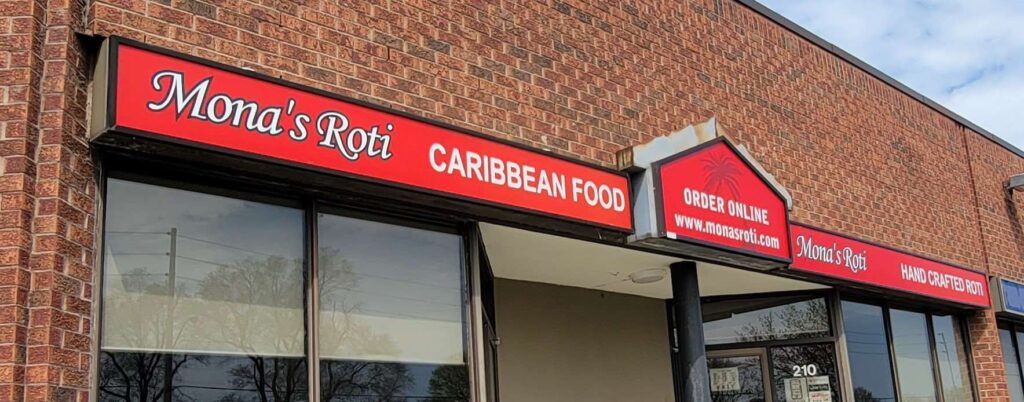 Exterior and red sign outside of Mona's Roti location in Scarborough.