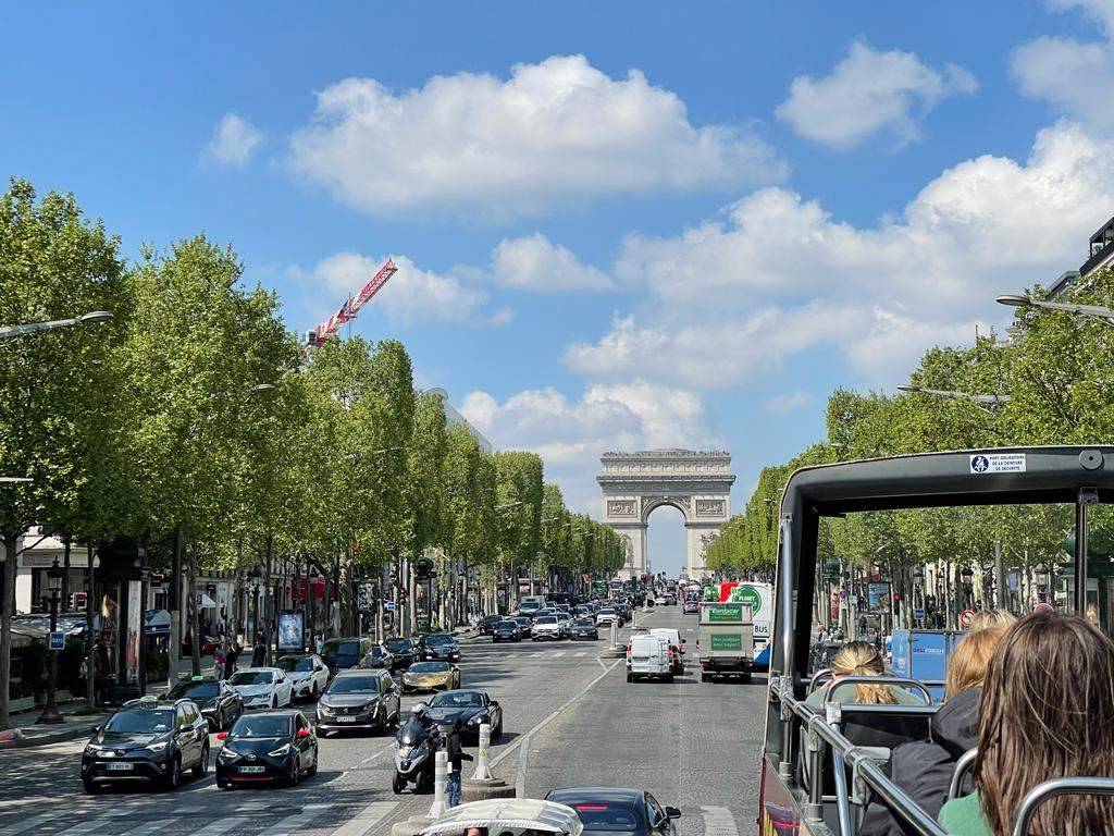 View from Big Bus Paris on Champs-Elysees with Arc de Triomphe in the distance, in Paris, France.