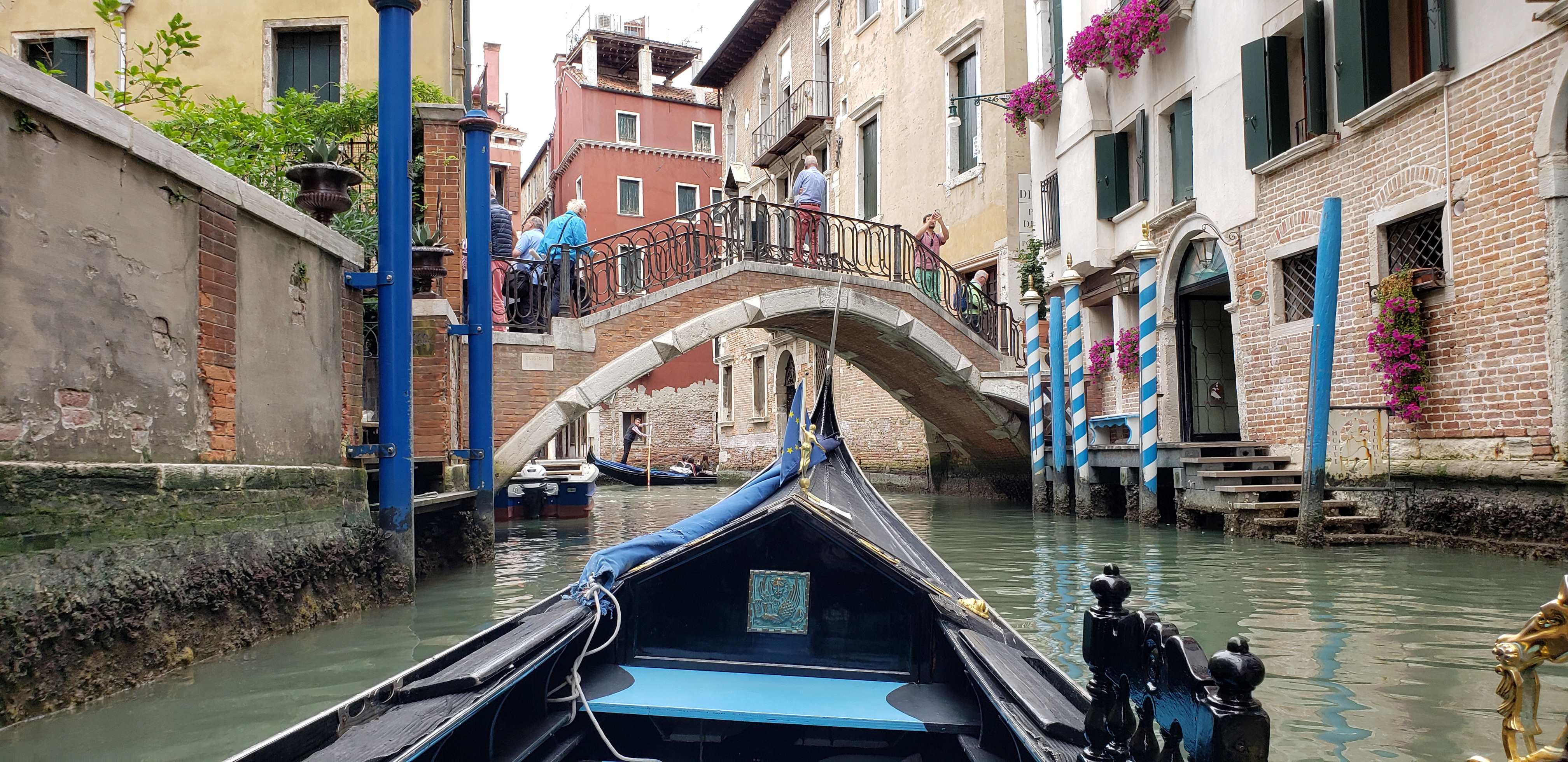 View from gondola in Venice approaching bridge.