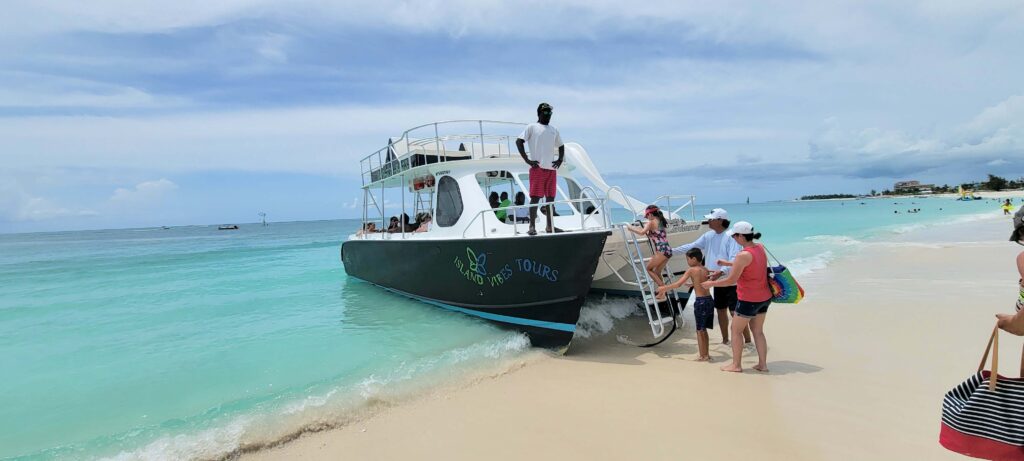 A family boarding a boat from Grace Bay beach for group half-day snorkel excursion in Turks and Caicos.