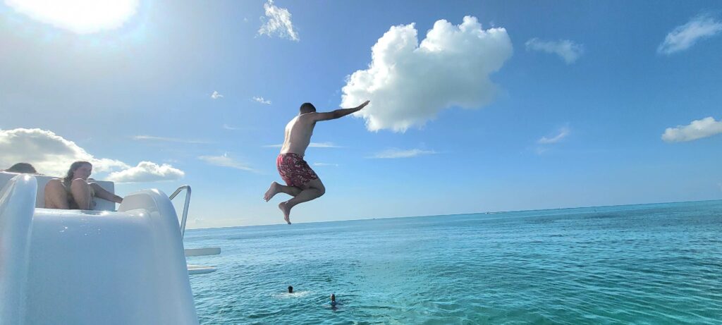 Man jumping off the top of the tour boat into the water in Turks and Caicos.