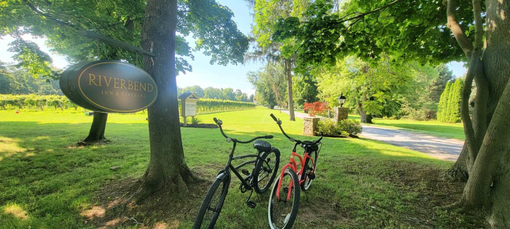 Two Bikes at Riverbend Inn entrance by vineyards and sign in Niagara-on-the-Lake.