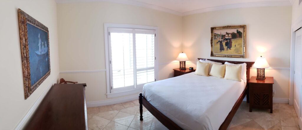 Spacious second bedroom with elegant wood furnishings and window.