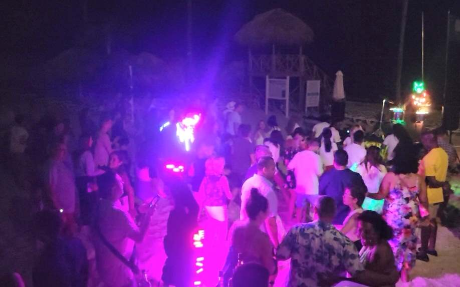 Dancing and beach party at night with other guests at the resort.