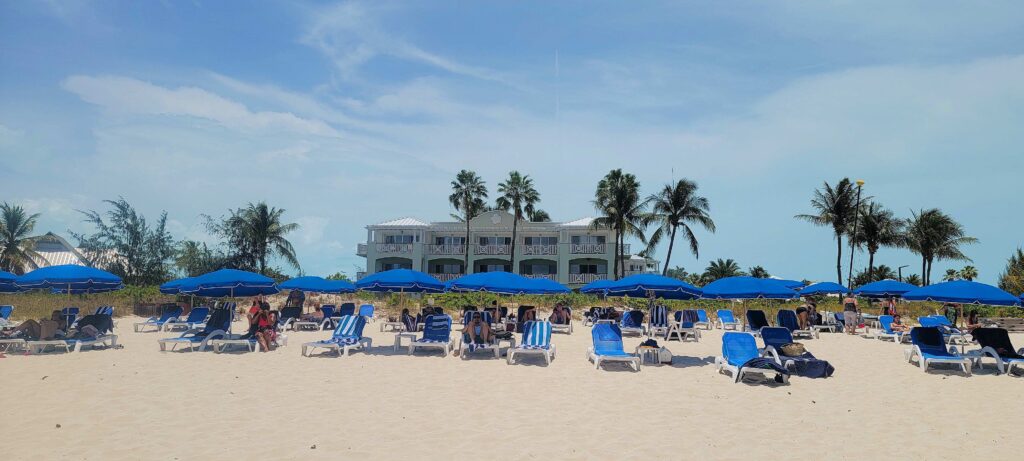 Spacious beachfront of Royal West Indies Resort in Turks and Caicos, of beach loungers and umbrellas.