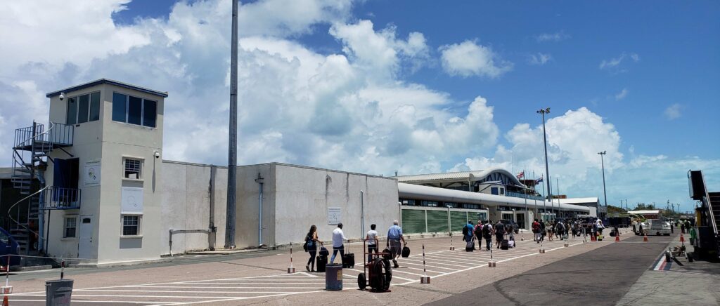 Exterior of Providenciales Airport in Turks and Caicos, arriving on a sunny afternoon, disembarking from airplane.