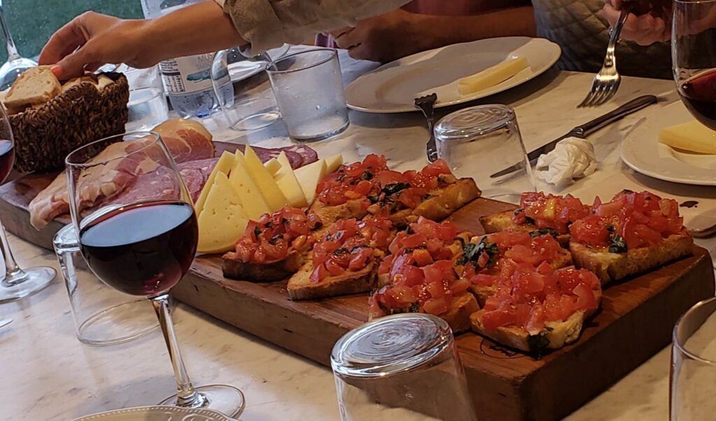 Board of bruschetta, cheese, and salami, with a basket of bread, served during our Florence Vespa Tour.