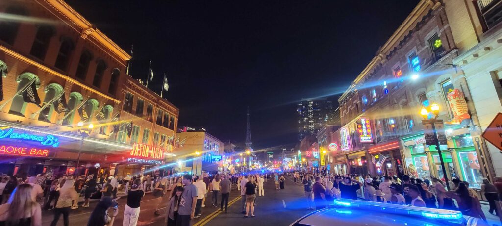 Lower Broadway in downtown Nashville on a Saturday night, lit up with lights and closed off to cars.   