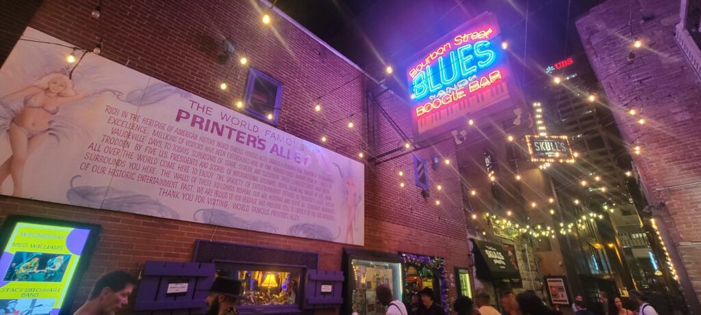 Signage and lights at Printer's Alley at night in Nashville.