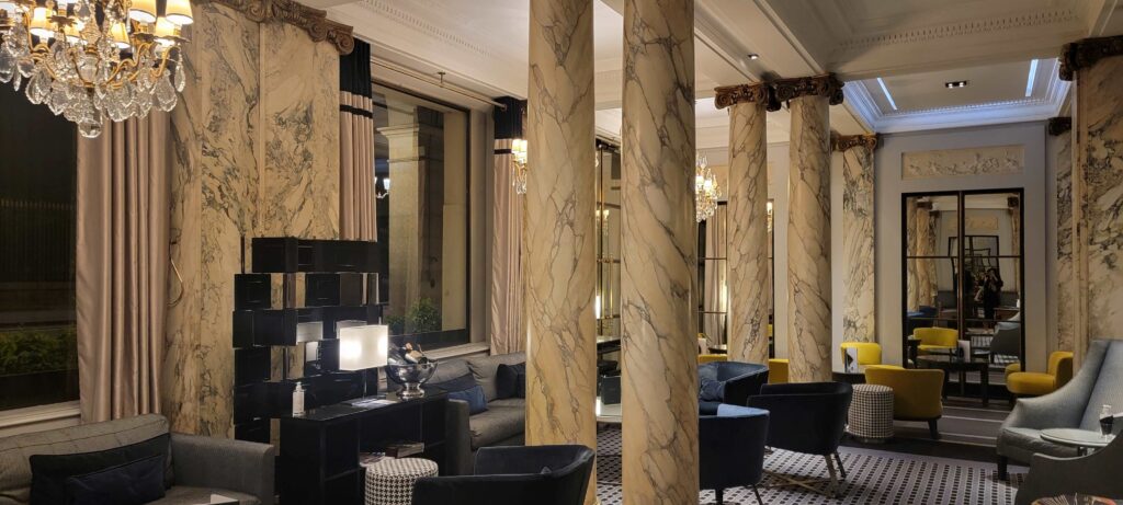 Lobby with seating, chandeliers, and elegant decor at the Hotel Brighton Paris.