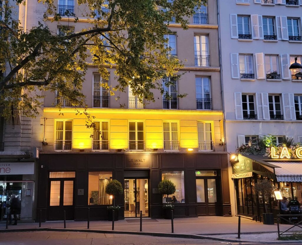 Exterior of Hotel Le Walt in the evening.