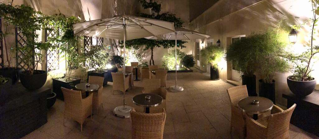 Private patio and garden at night at Hotel Le Walt in Paris.