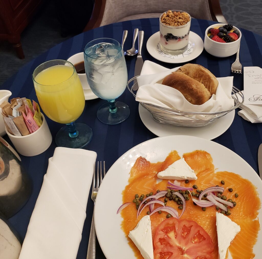 Breakfast room service we ordered at Fairmont Copley Plaza Boston which included smoked salmon, bagel, juice, fresh fruit, and yogurt.