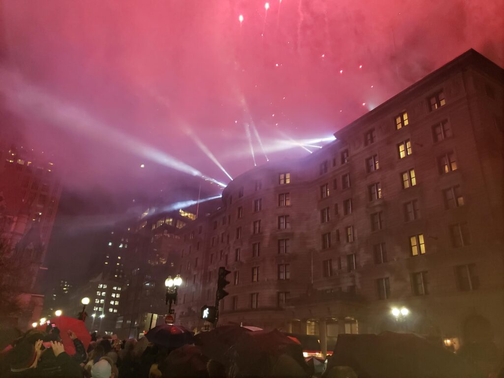 Exterior of Fairmont Copley Plaza Boston on New Year's Eve with fireworks in the background.