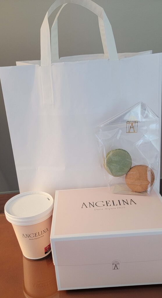 Paper bag and to-go purchases from Angelina Paris on a desk.