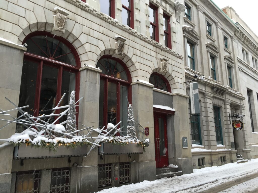 Exterior of Hotel Le Germain Quebec during the day in winter with snow on the windows and sidewalk.