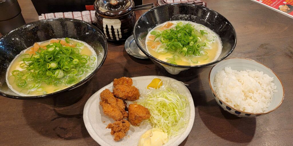 Two bowls of chicken ramen, fried chicken, and bowl of white rice.