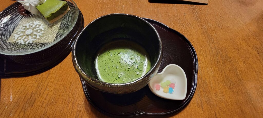 Matcha tea served in black tea cup and saucer.