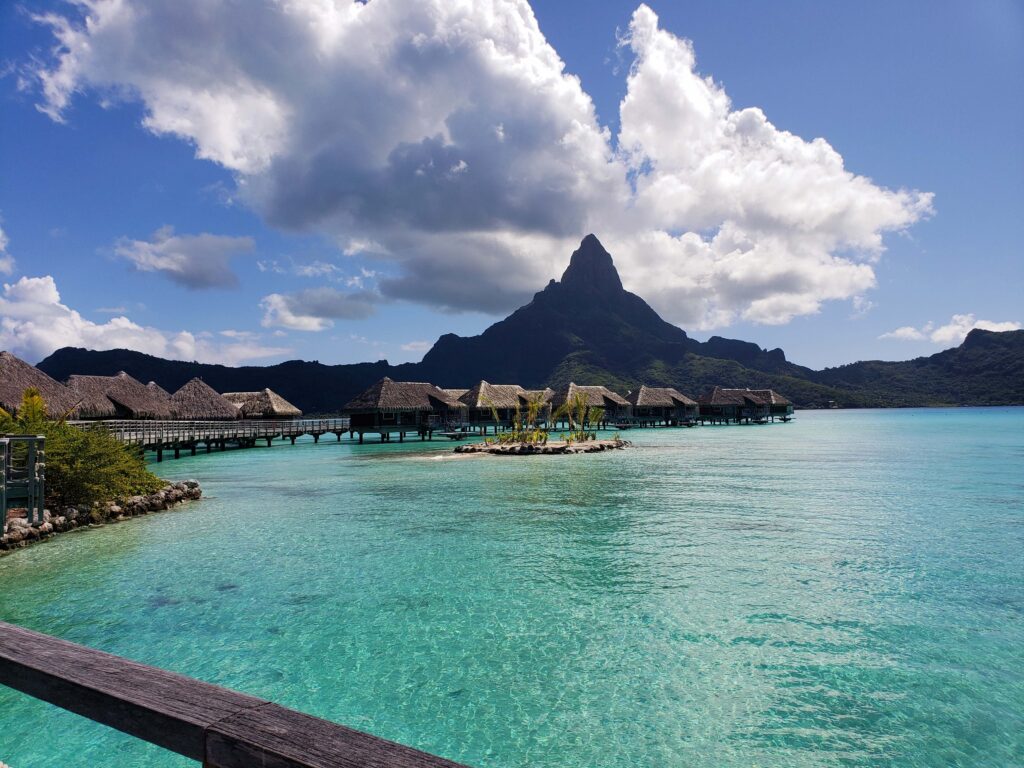 Beautiful view of overwater villas, lagoon, and Mount Otemanu on a sunny day at the InterContinental Bora Bora Resort & Thalasso Spa.