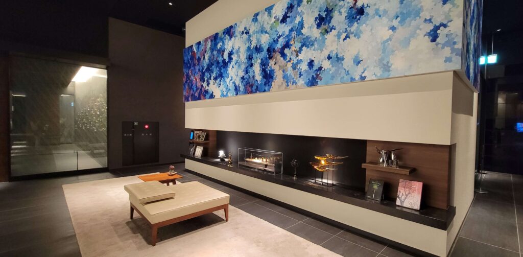 Seating area by an electric fireplace and decor, by the entrance of Mitsui Garden Hotel Toyosu Premier.