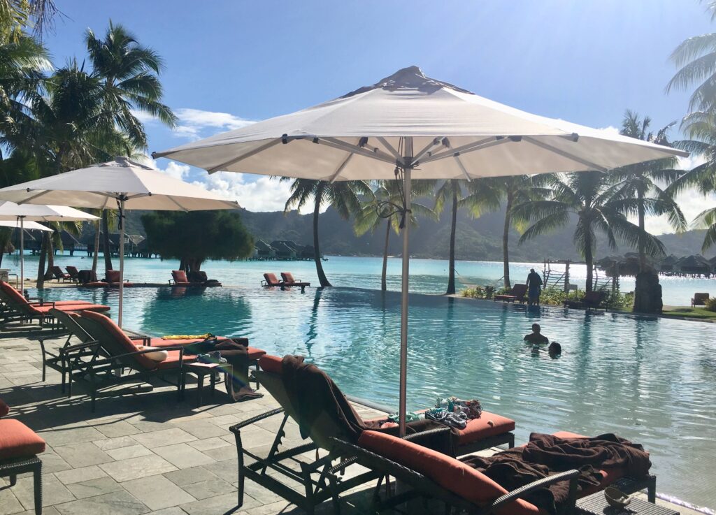 Infinity pool and loungers on a sunny day at InterContinental Bora Bora & Thalasso Spa.